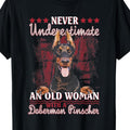 Men's Doberman Pinscher Graphic T-Shirt - "Never Underestimate an Old Woman" Slogan, Black Casual Short Sleeve Tee, Regular Fit, All-Season Comfort, Sizes S-XXXL, Comfortable Clothing, Dog Lover Apparel, Comfortable Fabric